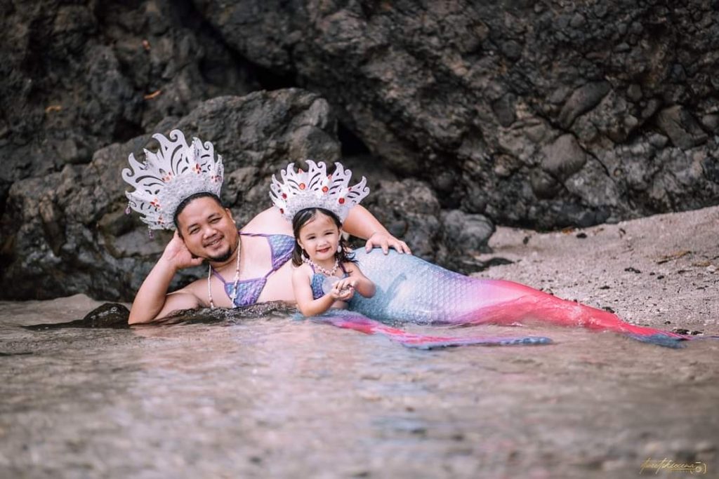 Tatay wears a merman costume for her little girl's photo shoot.