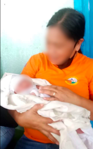 A rural health worker takes care of the baby girl found on a grassy lot in Barangay Dumlog, Talisay City. | Contributed photo