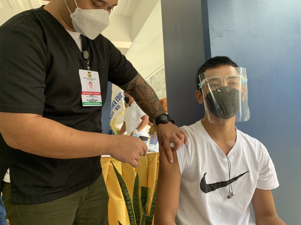 Photo of a college student getting his COVID-19 vaccine for story:CHD to Cebu City residents: Take advantage of 'Toktok Bakuna Program'