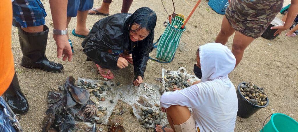 Some of the fisherfolk scour the shoreline for shells that they later cooked for breakfast during the protest rally. | Futch Anthony Inso