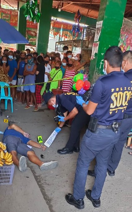 A lay minister is killed inside the Inayawan Public Market. In photo are policemen processing the crime scene.