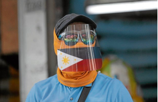 FILE PHOTO: A traffic enforcer wears a face shield with the image of the National Color as he monitors the proper wearing of face shield and face mask in Taytay Public Market in Taytay, Rizal on Tuesday, August 11, 2020, as the municipality passes an ordinance requiring the use of face shield in public places. INQUIRER / GRIG C. MONTEGRANDE