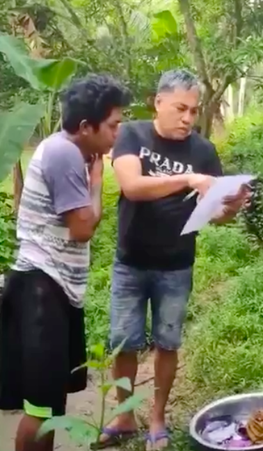 BARILI ARREST. A police officer shows Niñomar Tugot the warrant of arrest for murder against Tugot. The accused was arrested this morning, November 11, in his home in Barili Town. | screen grab from AKG-VFU video of the arrest 