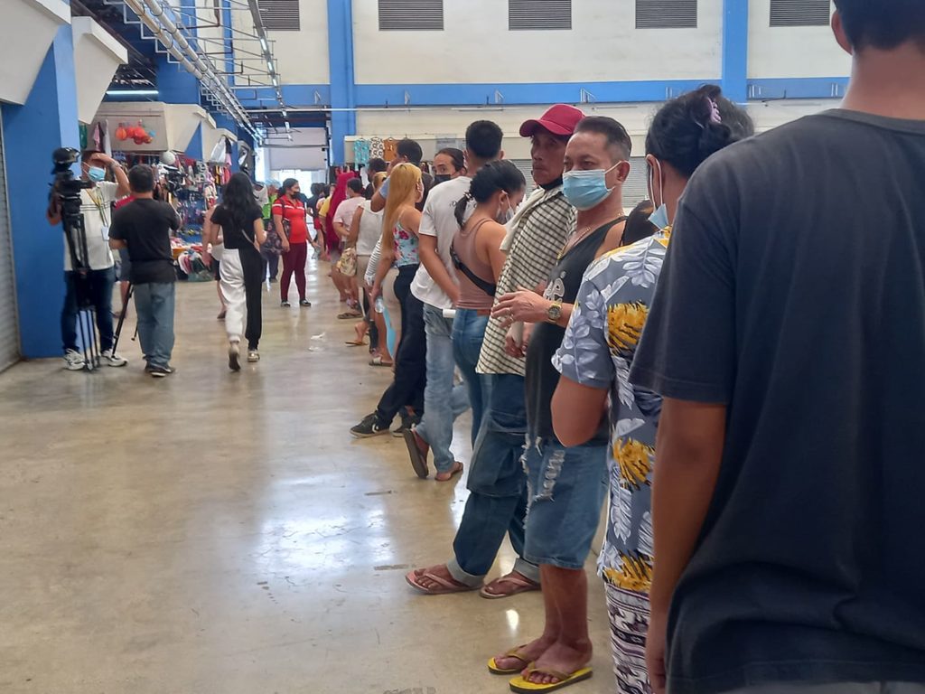 Vendors of the Mandaue Public Market wait in line for their turn to get vaccinated at the second of the public market where the "Bakuna Para ni Suki" drive is held today, December 6. | Mary Rose Sagarino