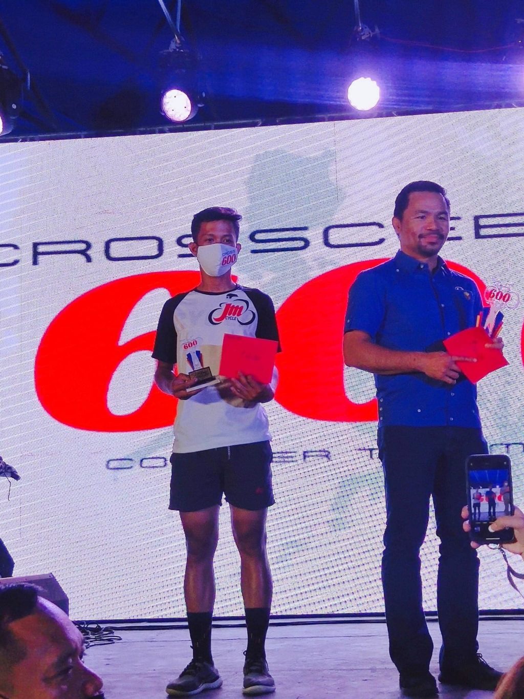 SENIOR HIGH SCHOOL STUDENT TABOADA WINS. Kylle Taboada (left) holds the plaque during the awarding ceremonies of the Cross Cebu 600 in November.  Presidential aspirant and senator Manny Pacquiao, who sponsored the major race, graced the event. | File photo