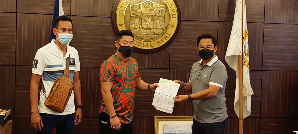 Daanbantayan Mayor Sun Shimura hands over the P100,000 check, which is the financial assistance donated from the town to Lapu-Lapu City, to Mayor Junard Chan. | Photo courtesy of Lapu-Lapu PIO