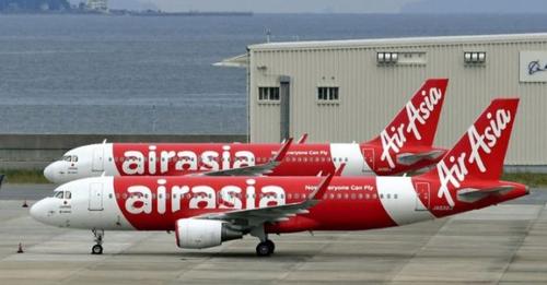Two AirAsia planes on he runway of an airport in PH.