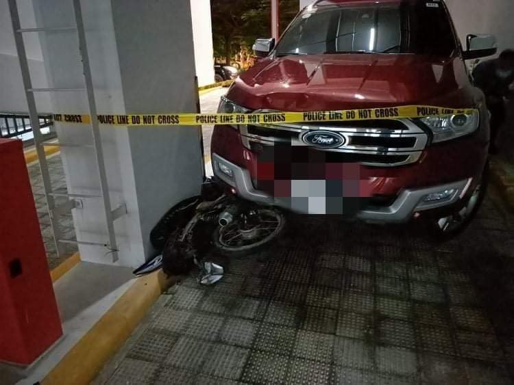 Police cordons the area where the SUV, Ford Everest, with a motorcycle stuck under it, at a condominium parking lot in Barangay Guadalupe. Police arrested the driver of the vehicle, who was a hit-and-run suspect. | Contributed photo
