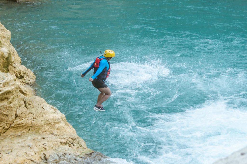 BADIAN CANYONEERING. A guest dives into cool waters during the Badian Canyoneering Adventure.