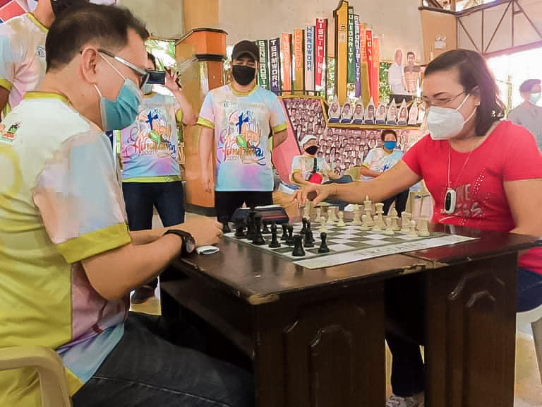 Trojans to hold Toledo inter-cities, municipalities chess tourney on May 28, 29. In photo is Toledo City Mayor Marjorie Perales (in red shirt) making the ceremonial move in last year's Hinulawan Toledo-Joyful Inter-Cities & Municipalities Chess Tournament. He was joined by International Master (IM) Rico Mascariñas. | Photo from Toledo City PIO