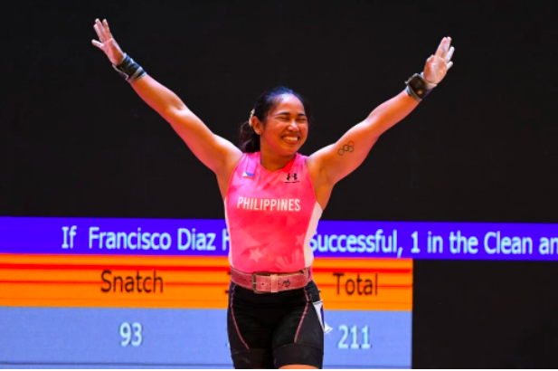 Philippines’ Hidilyn Diaz celebrates as she wins gold in the women’s 55kg weightlifting event during the 31st Southeast Asian Games (SEA Games) in Hanoi on May 20, 2022. (Photo by Tang Chhin Sothy and TANG CHHIN SOTHY / AFP)