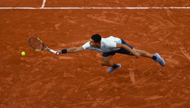 Spain’s Carlos Alcaraz stretches to return the ball to Spain’s Albert Ramos-Vinolas during their men’s singles match on day four of the Roland-Garros Open tennis tournament at the Court Simonne-Mathieu in Paris on May 25, 2022. (Photo by Christophe ARCHAMBAULT / AFP)