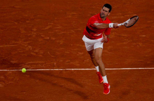 Serbia’s Novak Djokovic returns the ball to Japan’s Yoshihito Nishioka during their men’s singles match on day two of the Roland-Garros Open tennis tournament at the Court Philippe-Chatrier in Paris on May 23, 2022. (Photo by Thomas SAMSON / AFP)