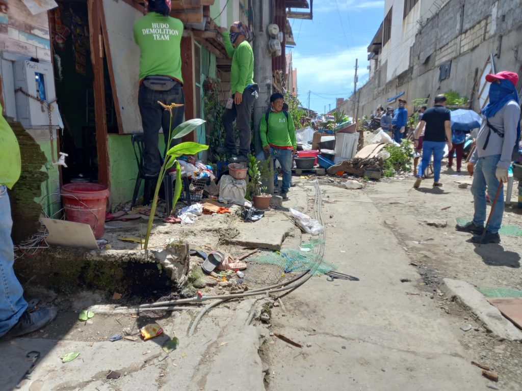 Personnel of the Housing, Urban and Development Office (HUDO) removes the extensions of five houses encroaching the road as part of the city's road widening and drainage projects. | Mary Rose Sagarino