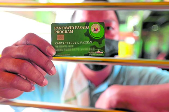 FILE PHOTO: A jeepney driver shows his “Pantawid Pasada Program” card while waiting for passengers at a transport terminal on Visayas Avenue in Quezon City. This photo was taken on March 16, 2022. —GRIG C. MONTEGRANDE