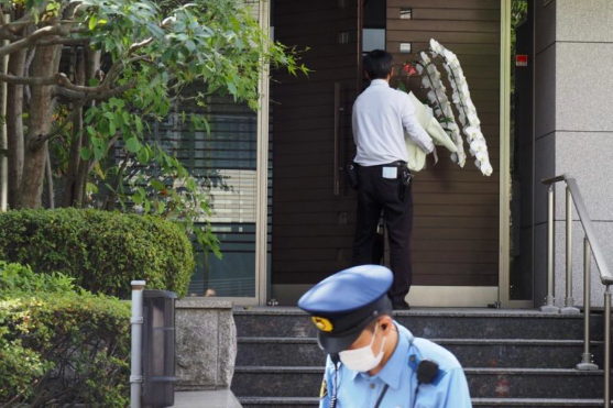 A man carries flowers at the residence of former Japanese prime minister Shinzo Abe in Tokyo on July 9, 2022. – World leaders have recoiled in horror after Japan’s former prime minister Shinzo Abe was shot dead during a campaign speech on July 8 — an especially shocking assassination given the country’s strict gun laws and low rates of violent crime. (Photo by TOSHIFUMI KITAMURA / AFP)