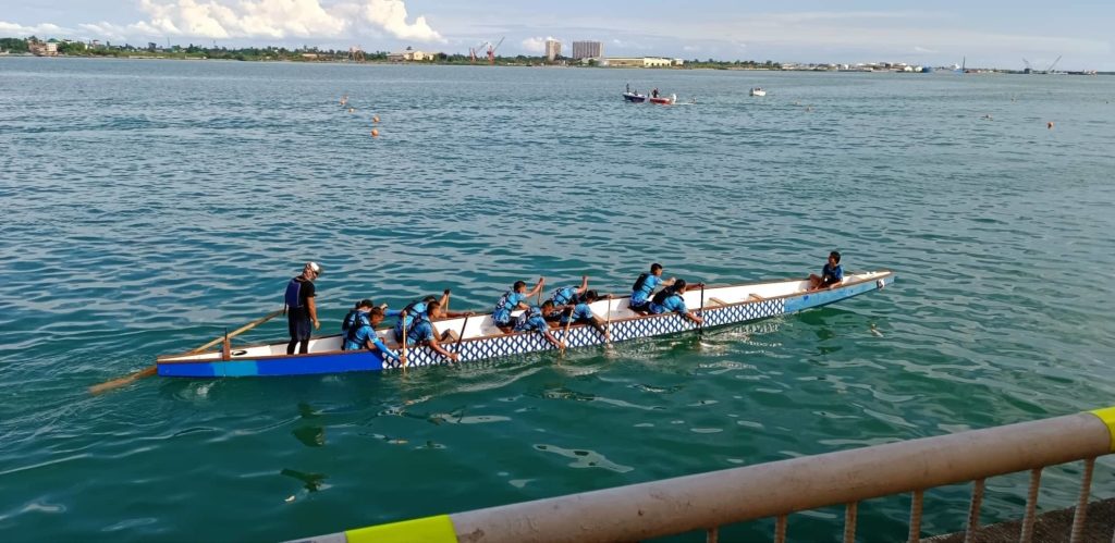 A dragon boat team paddles their way to the starting line during the Mandani Bay Dragon Boat Regatta. | Photo by Glendale Rosal