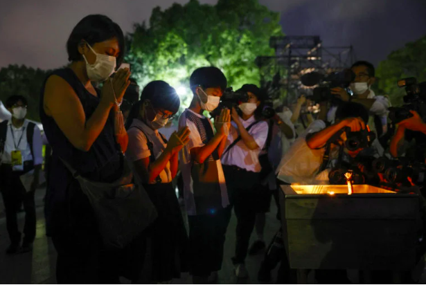 People pray in front of the cenotaph for the victims of the 1945 atomic bombing, on the 77th anniversary of the world’s first atomic bombing, at Peace Memorial Park in Hiroshima, western Japan, August 6, 2022, in this photo taken by Kyodo. (Kyodo via REUTERS)