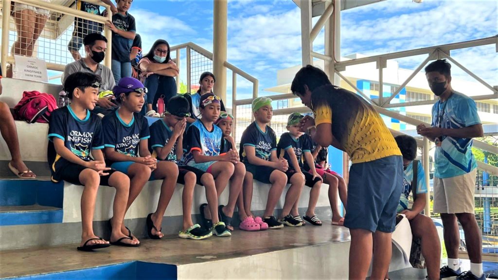 The Ormoc Kingfisher Swim Team tankers or Ormoc Kingfishers are given last minute instructions before competing in their respective events in the Sacred Heart School-Ateneo de Cebu (SHS-AdC) Invitational Swim Meet on Saturday, Sept. 24, 2022. | Photo from the Ormoc Kingfisher Swim Team Facebook Page.