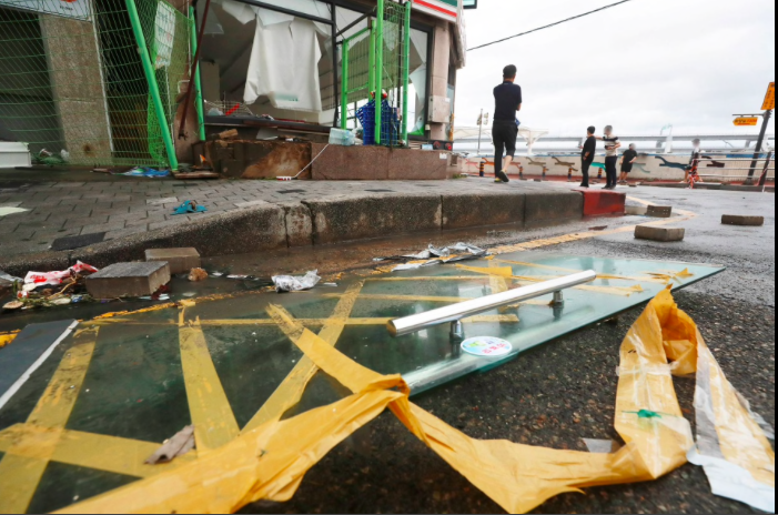 People stand at a shopping district damaged by Typhoon Hinnamnor in Busan, South Korea, September 6, 2022. Yonhap/via REUTERS