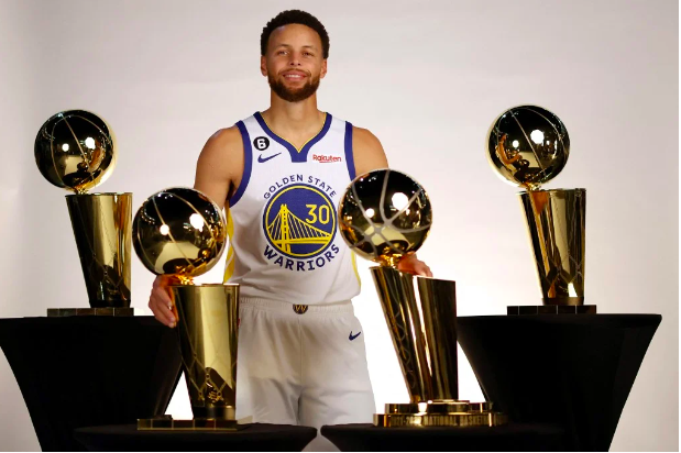 Stephen Curry #30 of the Golden State Warriors poses with the four Larry O’Brien Championship Trophies that he has won with the Warriors during the Warriors Media Day on September 25, 2022 in San Francisco, California. Ezra Shaw/Getty Images/AFP