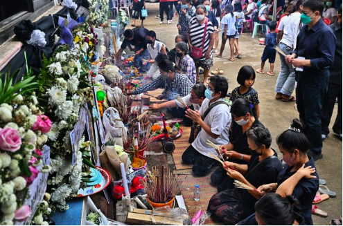 People pray for the victims of the nursery mass shooting at Wat Rat Samakee temple in northeastern Nong Bua Lam Phu province on October 10, 2022, as relatives hold funeral rites for those killed in the massacre. AFP