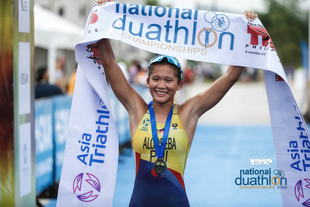 Raven Faith Alcoseba raises the finish line tape after topping the women's elite sprint distance of the National Duathlon Championships in Tarlac. | Photo from the National Duathlon Championships Facebook page