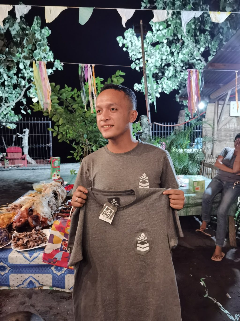It’s a 'not-so-surprise' Christmas present in Bukidnon! Jaymart Cosina holds up the shirt that he received at the Christmas party's exchange gift portion -- a similar t-shirt that he was wearing that night of the party. | Contributed photo