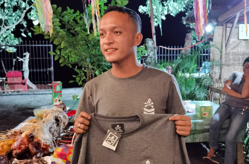 Jaymart Cosina holds up the shirt that he received at the Christmas party's exchange gift portion -- a similar t-shirt that he was wearing that night of the party. | Contributed photo