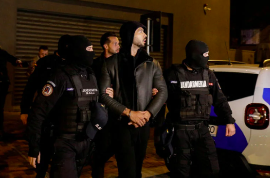Andrew Tate and Tristan Tate are escorted by police officers outside the headquarters of the Directorate for Investigating Organized Crime and Terrorism in Bucharest (DIICOT) after being detained for 24 hours, in Bucharest, Romania, December 29, 2022. Inquam Photos/Octav Ganea via REUTERS