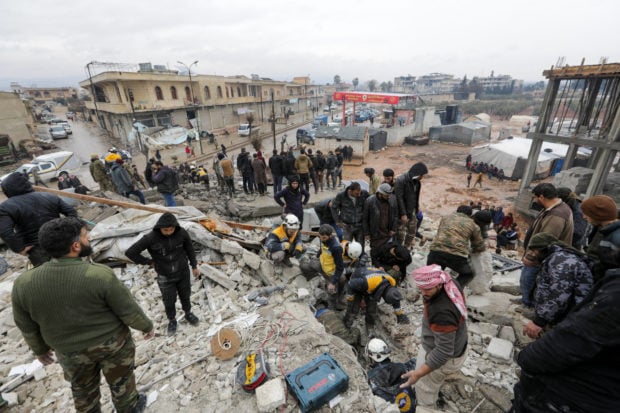 Syrians gather as rescuers search for survivors under the rubble, following an earthquake, in rebel-held town of Jandaris, Syria February 6, 2023.