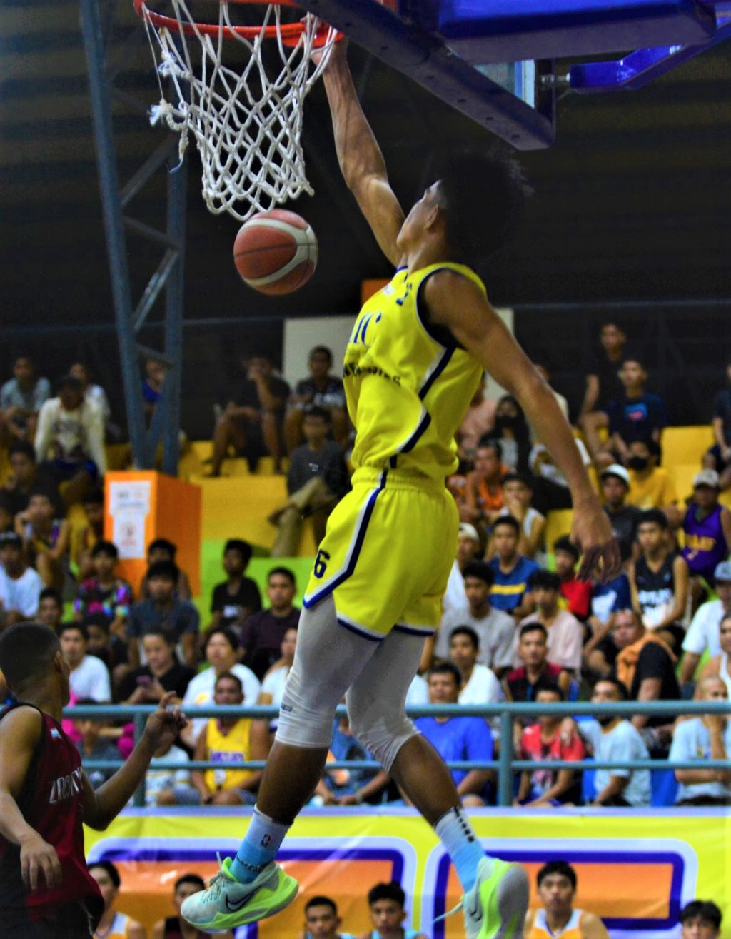 UC Baby Webmasters' Mark Solonia hangs on the rim after a dunk in their exhibition game against the OCCCI D-League North Leyte all stars on Saturday evening in Jaro, Leyte. | Photo from the OCCCI D-League Facebook page