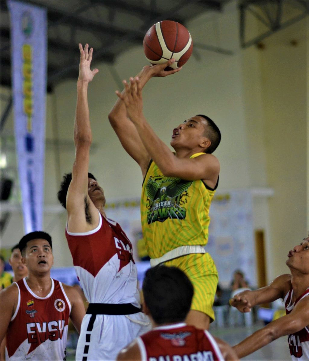 Mark Lester Montanes of St. Joseph College of Maasin breaks through the defense of EVSU to make his shot in the college division of the OCCCI D-League over the weekend. | Photo from OCCCI D-LeagueCEBU CITY, Philippines —The Saint Joseph College of Maasin Green Hawks and Baybay Senior High School put on dominating performances over the weekend in the OCCCI D-League Inter School Basketball Tournament South of Leyte Division at the Franciscan College of the Immaculate Conception (FCIC) gym in Baybay City, Leyte. The Green Hawks and Baybay SHS finished the first three days of the tournament with a clean 3-0 (win-loss) record after beating all their opponents in their scheduled matches. The Green Hawks opened their campaign with a lopsided win against the FCIC Heralds, 105-55, and went on to narrowly beat the Sto. Nino College of Ormoc, 69-66. They wrapped up the first weekend of competition with a win against the Eastern Visayas State University, 70-62. Trailing behind them in the team standings is the Western Leyte College with a 2-0 record, followed by Sto. Nino College of Ormoc (1-2), and EVSU (1-2). Meanwhile, Baybay SHS started their campaign with a blistering start after beating Baybay Fisheries High School, 63-43, in the high school division Bracket A. They also beat Saint Joseph's College of Maasin, 59-51, and escaped FCIC Heralds of Baybay, 94-92, in their final game. In Bracket B, Baybay National High School and St. Joseph's College of Maasin are tied with a 2-1 record. On the other hand, Libas Elementary School and Baybay 1 District Central School each scored a win in the elementary division. The hardcourt action will resume this weekend at the same venue. Mark Lester Montanes of St. Joseph College of Maasin breaks through the defense of EVSU to make his shot in the college division of the OCCCI D-League over the weekend. | Photo from OCCCI D-League