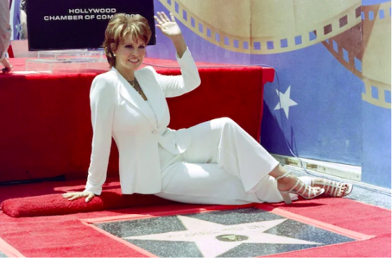 Actress Raquel Welch waves to photographers and fans as she sits in front of her newly unveiled star on the Hollywood Walk of Fame on June 8, 1996 in Hollywood, California. (File photo by KIM KULISH / Agence France-Presse)