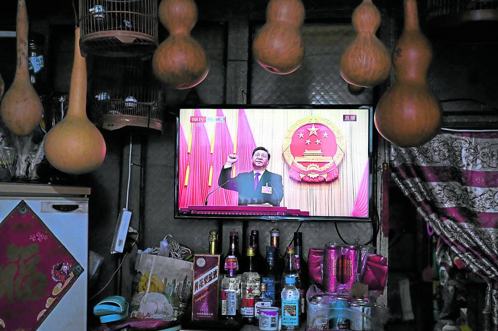 NATIONAL FIXTURE A TV screen at a convenience store shows live coverage as Chinese President Xi Jinping swears an oath after being reelected as president for a third term during the third plenary session of the National People’s Congress in Beijing on March 10, 2023.