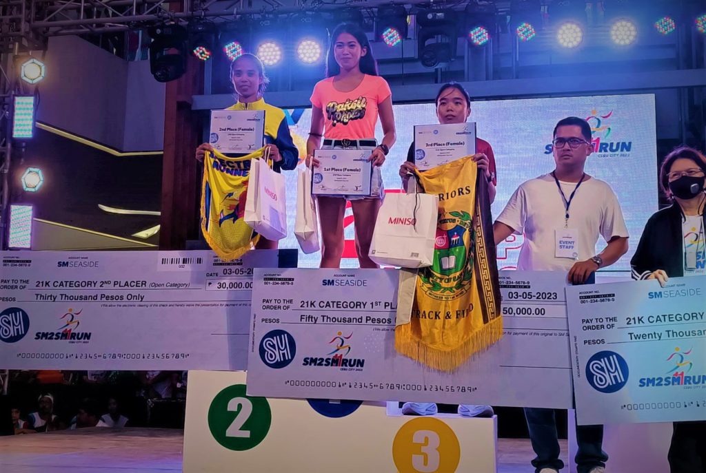 Cherry Andrin (on top of the podium) finally wins the 6K race and receives her prize during the awarding ceremony of the SM2SM Run 2023 at the SM Seaside City Cebu. | Glendale Rosal