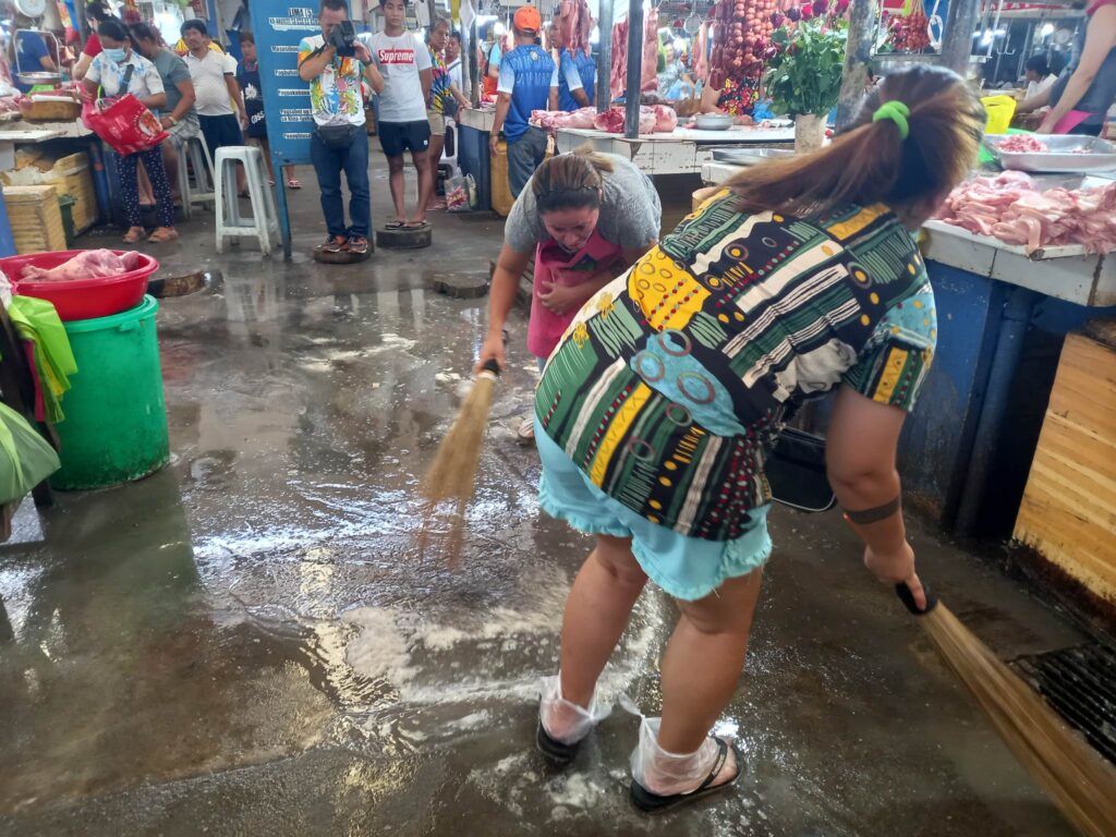 Vendors in the meat and fish section try to remove the pooled water in their area. | Mary Rose Sagarino