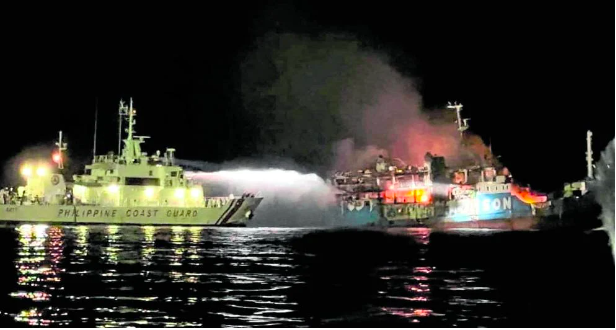 FIERY FERRY A Philippine Coast Guard ship tries to put out the blaze that swept through MV Lady Mary Joy 3, which caught fire off Basilan province as it was sailing to Sulu on Wednesday night (March 29, 2023). At least 29 died and 17 were missing from the fire that reportedly started in an air-conditioned cabin in the lower deck. —PHILIPPINE COAST GUARD/HANDOUT VIA REUTERS
