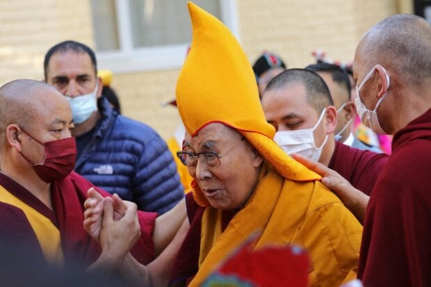 In this file photo taken on April 5, 2023, Tibetan spiritual leader Dalai Lama (C) arrives to attend a prayer at the Main Tibetan Temple in McLeod Ganj. 