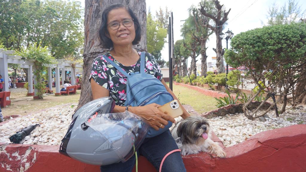 Holy Week is for fur babies, too. Nanay Fe and her pet Shih tzu, Cute, wait for Nanay Fe's husband to arrive at the Bantayan Heritage Plaza. | Morexette Marie Erram
