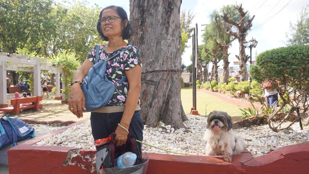 Nanay Fe and Cute, a shih tzu, wait for the former's husband at the Bantayan Heritage Plaza. | Morexette Marie Erram