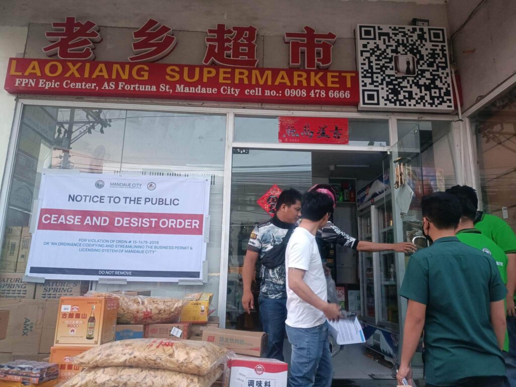Personnel of the Business Processing and Licensing Office of Mandaue City has closes the Liaoxing Supermarket after it issued a cease and desist order against the establishment for operating without the necessary permits. | BPLO photo