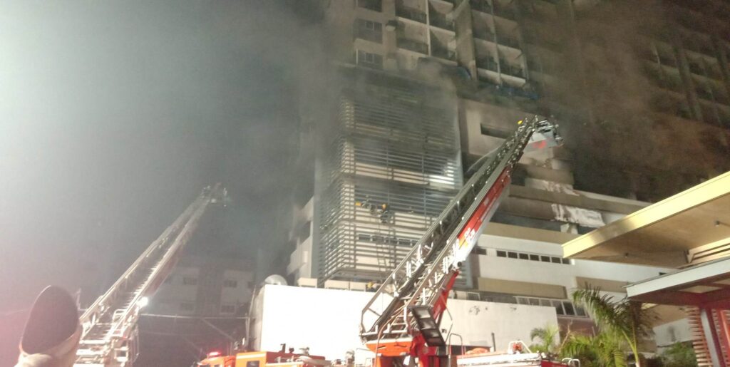 Firefighters at the height of the fire use aerial ladders to battle the fire that hit the high-rise condo building at Barangay Kasambagan on April 14, where damage to property was pegged at nearly P4 billion.
