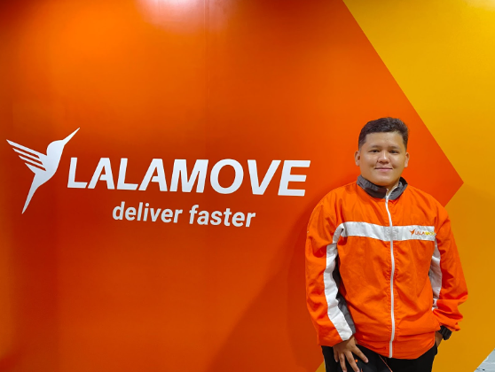 Lalamove motorcycle owner and partner driver Claudine Boholano pose infront of the Lalamove signage