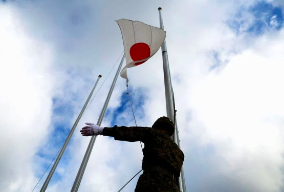 FILE PHOTO: A member of the Japan Ground Self-Defense Force (JGSDF) raises the Japanese national flag in the morning, at JGSDF Miyako camp on Miyako Island, Okinawa prefecture, Japan, April 21, 2022. REUTERS/Issei Kato
