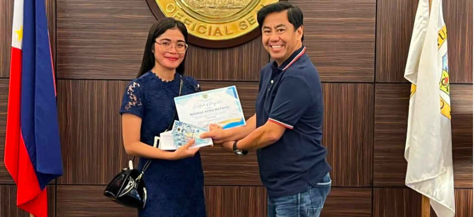 A board passer received her P5,000 cash incentive from Lapu-Lapu City Mayor Junard "Ahong" Chan. | Contributed photo