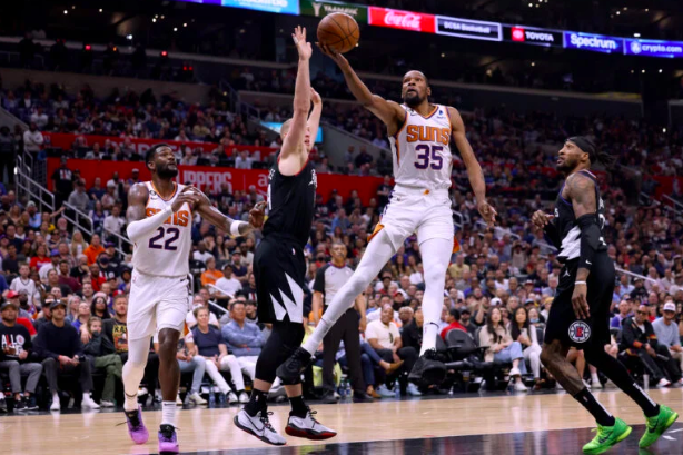 Kevin Durant of the Phoenix Suns scores on a layup between Mason Plumlee and Robert Covington of the LA Clippers during a 112-100 Suns win of Game Four of the Western Conference First Round Playoffs at Crypto.com Arena on April 22, 2023 in Los Angeles, California.  (Getty Images via AFP)