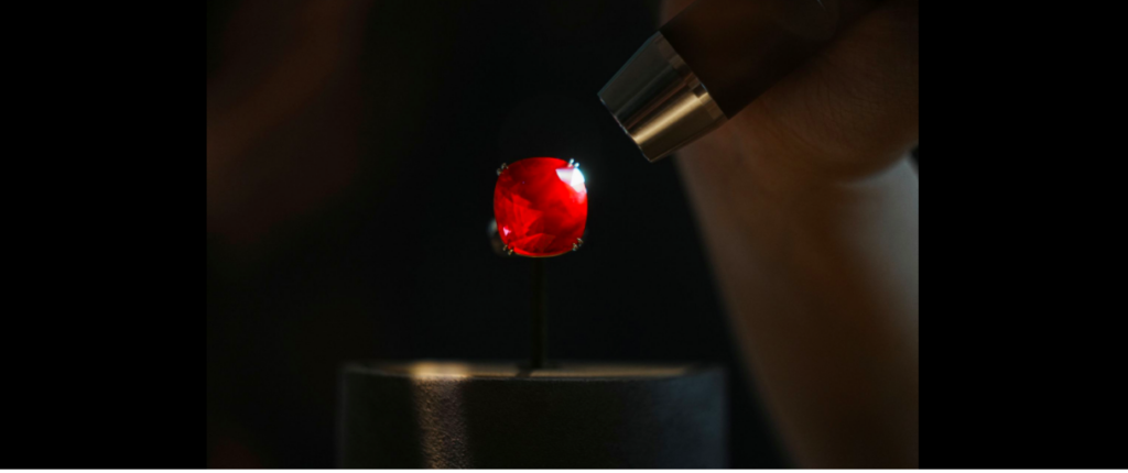 An employee shines a light at the 55.22 carat "The Estrela de Fura" ruby, the largest in the world and expected to fetch up to $30 million in an upcoming New York auction, during a preview at Sotheby's, in Hong Kong, China April 17, 2023. REUTERS/Lam Yik