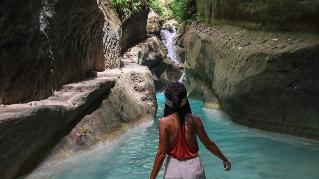 A girl navigating a hidden waterfall and stream