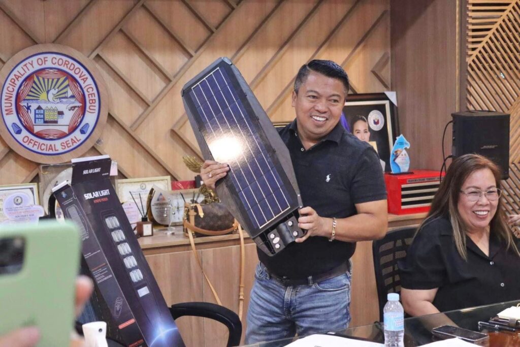 Mayor Cesar Suan shows a sample of the solar lights that he would soon distribute to the 13 barangays in their town.